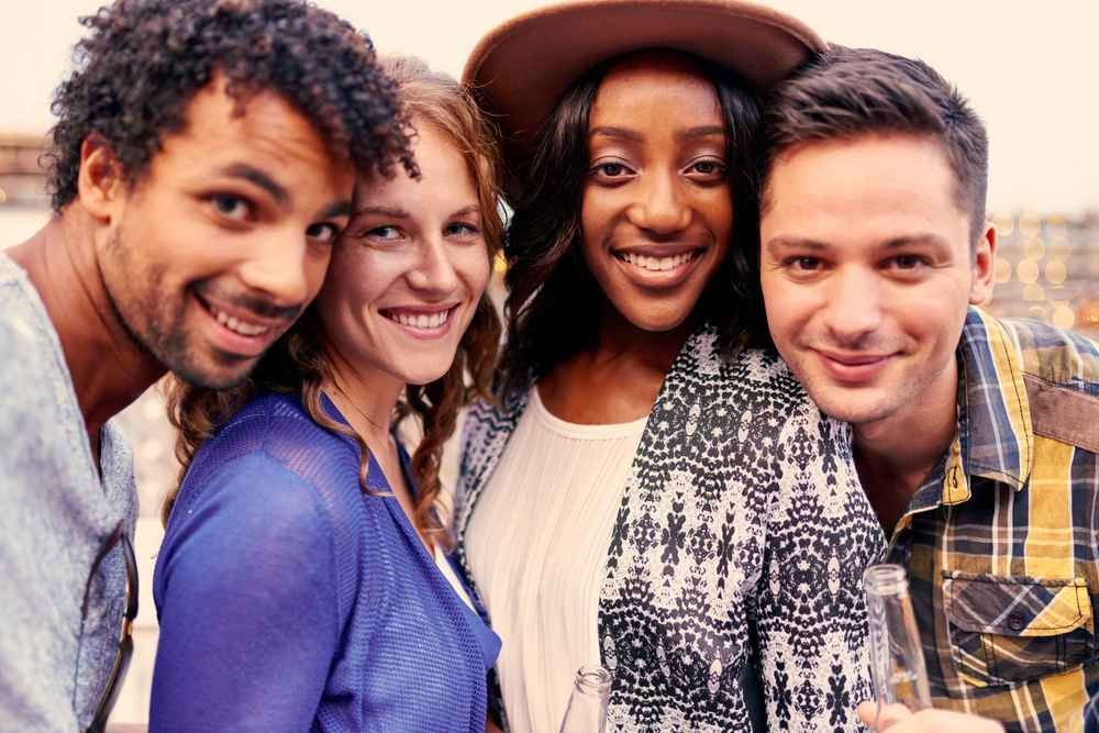 Multi-ethnic millenial group of friends taking a selfie photo with mobile phone on rooftop terrasse at sunset_11zon