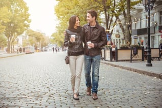 Portrait of a happy romantic couple with coffee walking outdoors in old european city-1_11zon